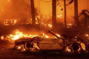 Flames consume vehicles as the Dixie Fire tears through California, Saturday, July 24, 2021. (AP Photo/Noah Berger)